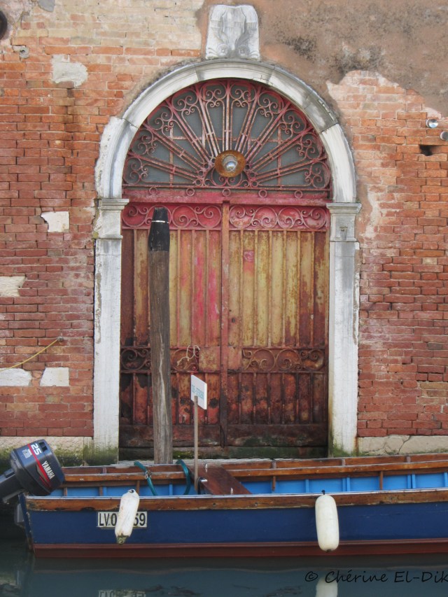 I love the colours in this photo. The door and boat seem to be complementing each other.